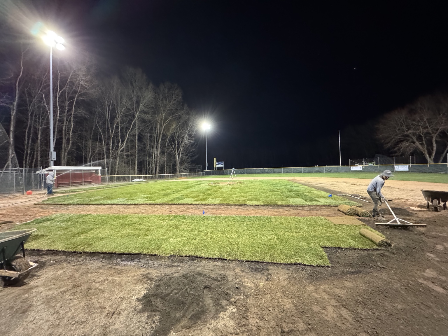 Crew installing sod at a community ballfield